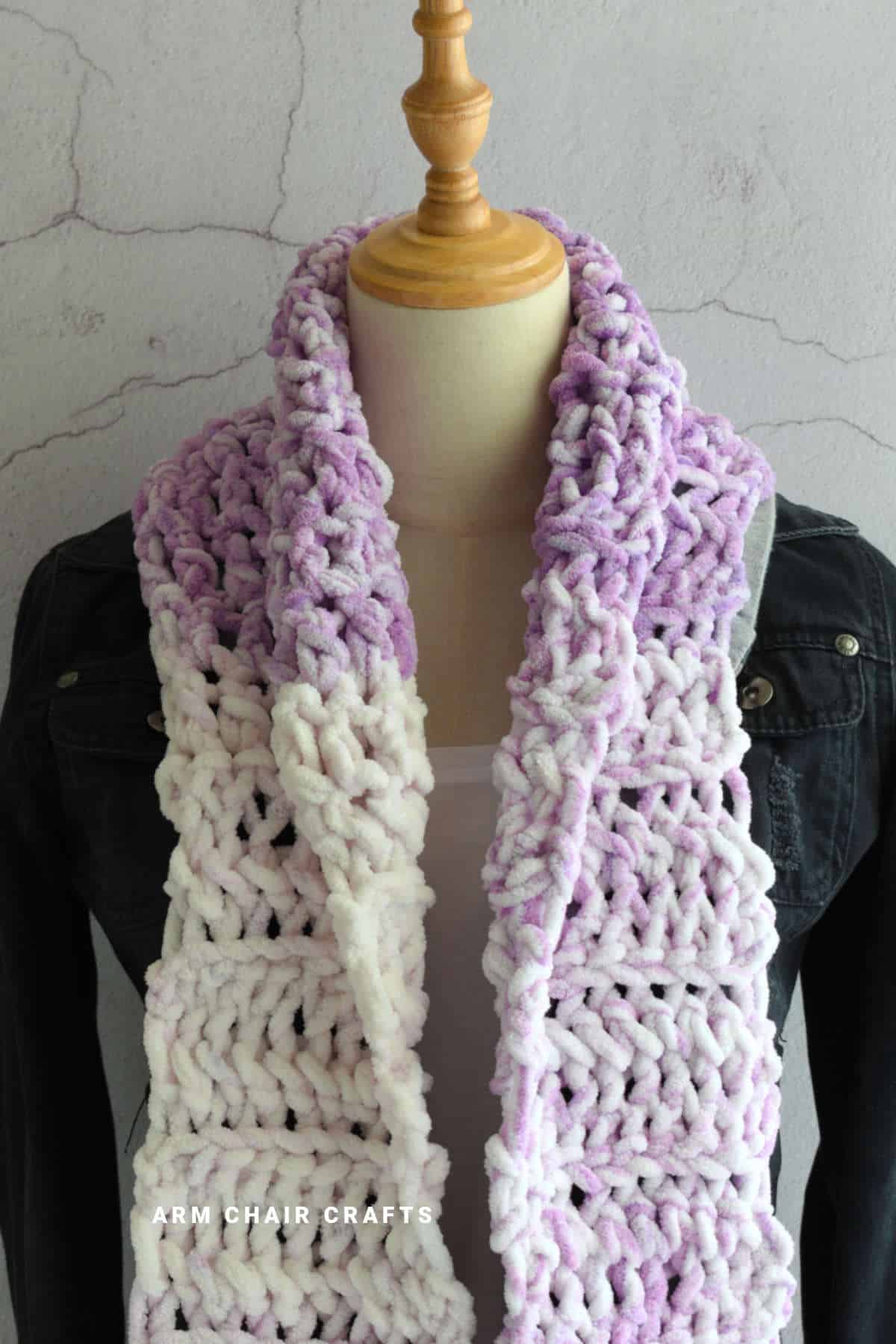 Purple crochet scarf on a mannequin.