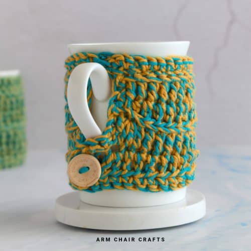 Blue and yellow crochet mug cozy.