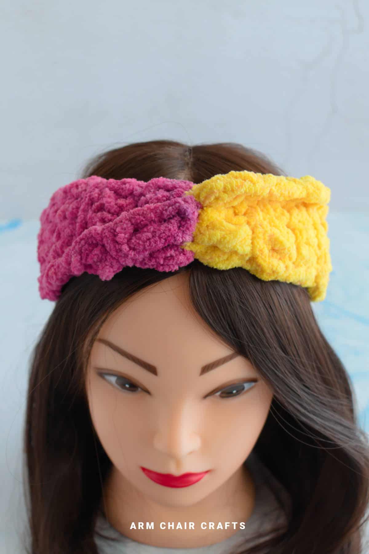 Close up image of a yellow and pink crochet headband.