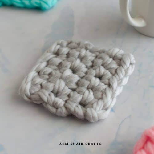 Close up image of a grey crochet coaster.