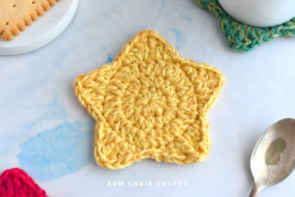 Yellow star crochet coaster.