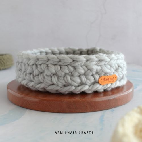 Close up image of a grey round crochet basket.
