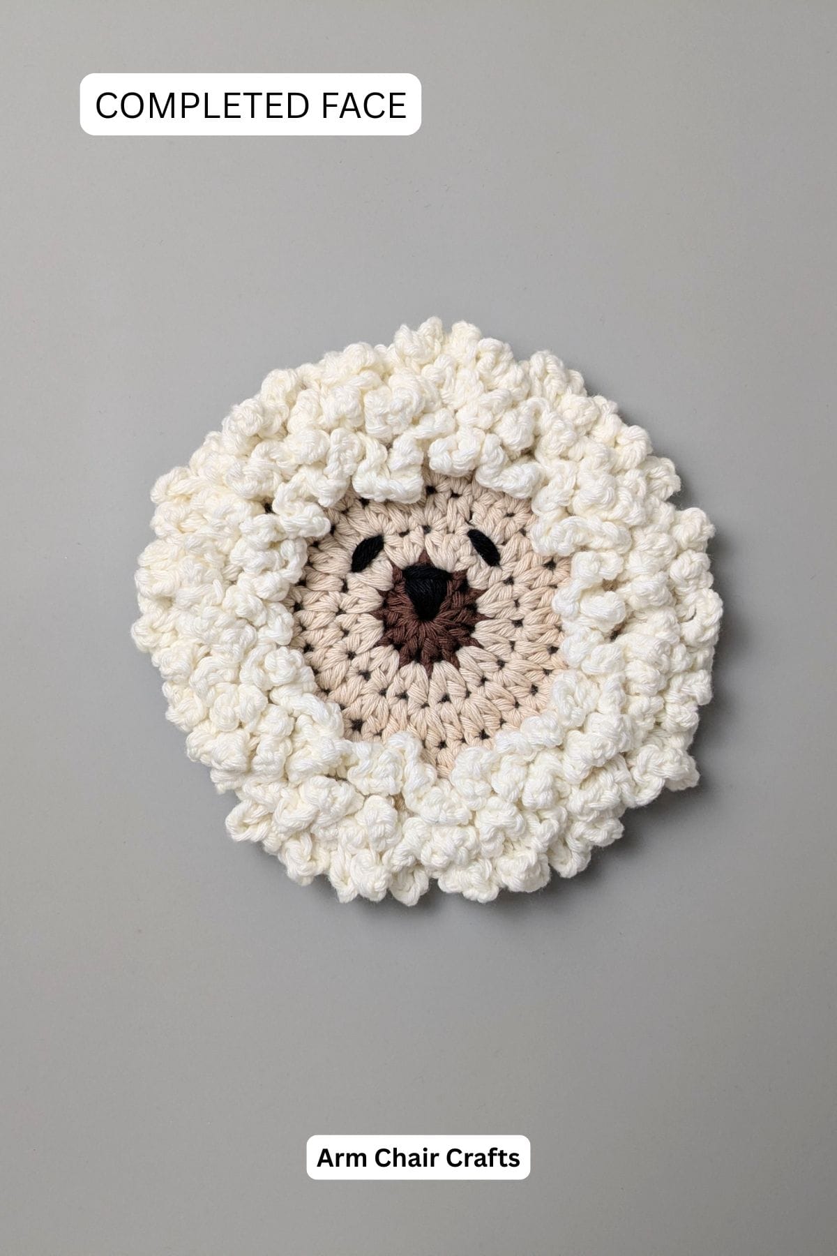 Completed crochet sheep coaster face.
