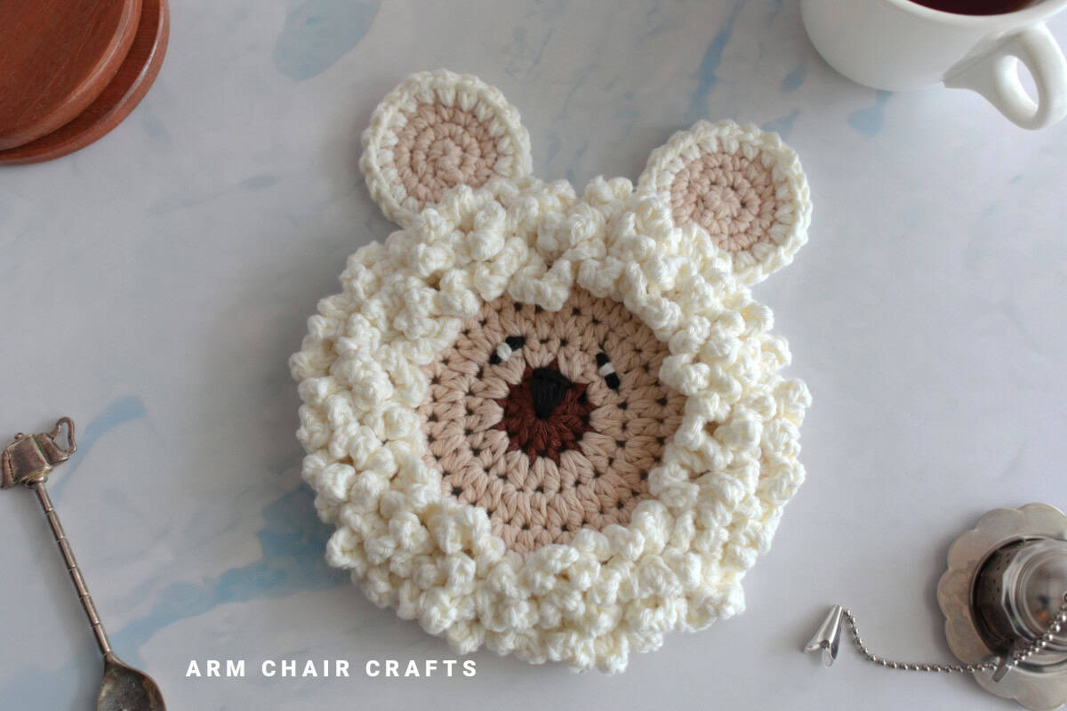 Close up image of a crochet sheep coaster.