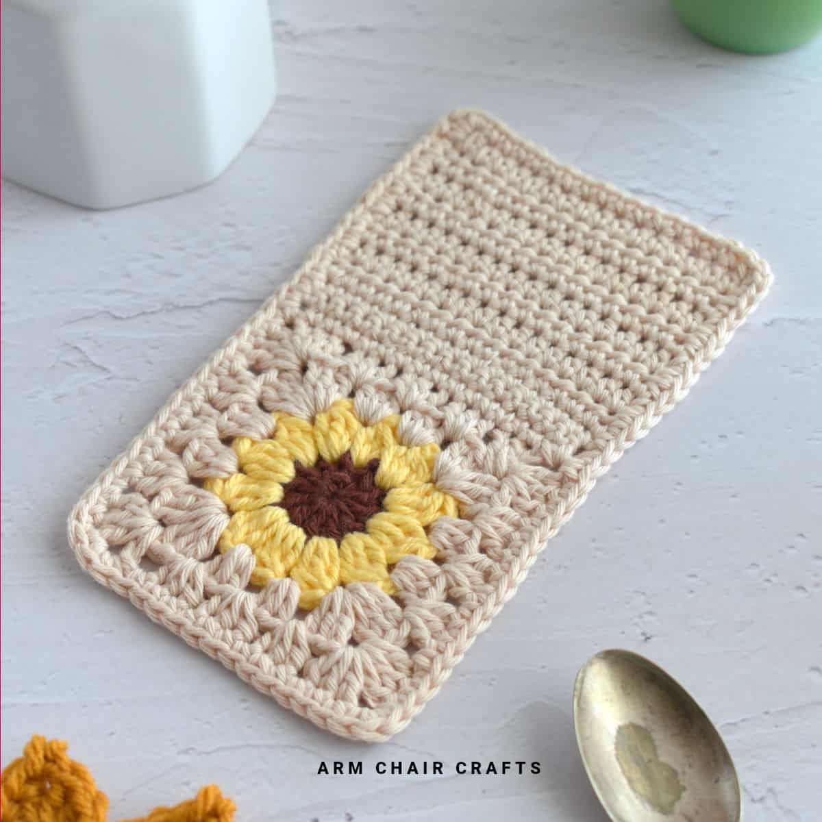 Close up image of a crochet sunflower mug rug.